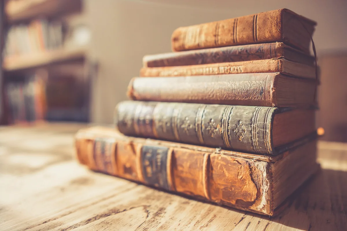 Pile de livres anciens reliés de cuir sur une table en bois